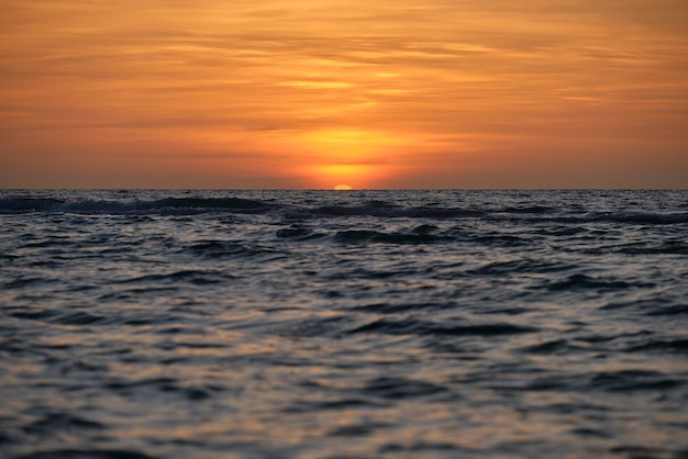 Oceaan zonsondergang Grote witte zon op dramatische heldere hemel achtergrond zachte avond horizont over zee donker water