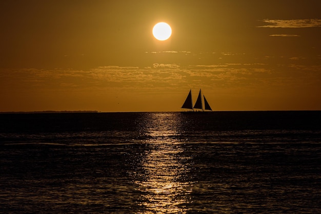 Oceaan zonsondergang zeilboot zeilen langs het oceaanwater bij zonsondergang zeilen bij zonsondergang