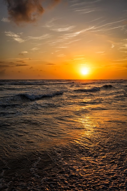 Oceaanzonsondergang met golven