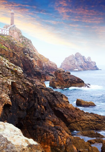 Foto oceano costa rocciosa con faro