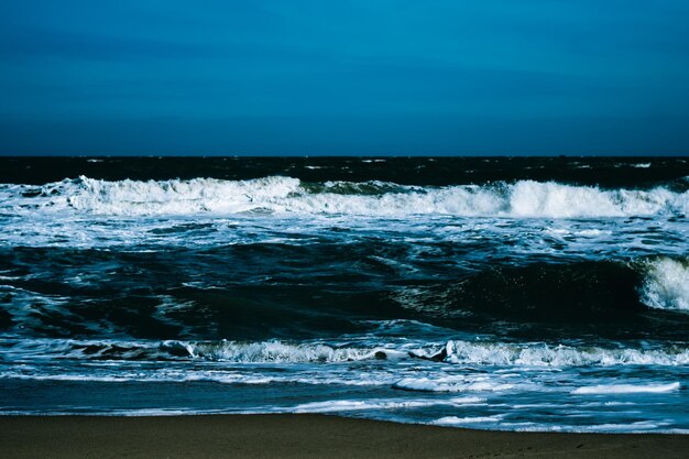 Ocean storm waves dramatically crashing splashing Sky horizon line Sea water edge nature front view marine wallpaper Bad weather cloudy overcast Dark green turquoise blue bright vivid contrast