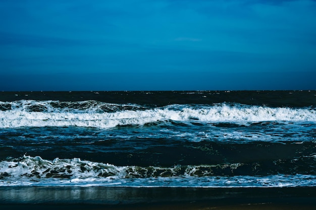 Ocean storm waves dramatically crashing splashing sky horizon\
line sea water edge nature front view marine wallpaper bad weather\
cloudy overcast dark green turquoise blue bright vivid\
contrast