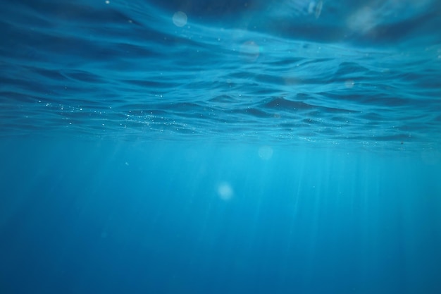 Ocean underwater rays of light background, under blue water sunlight