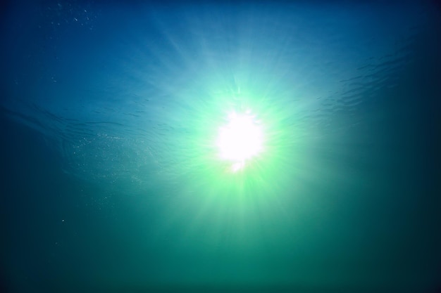 ocean water blue background underwater rays sun / abstract blue background nature water