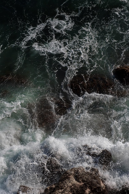 Fondo dell'onda dell'oceano che rompe la costa rocciosa dell'acqua di mare