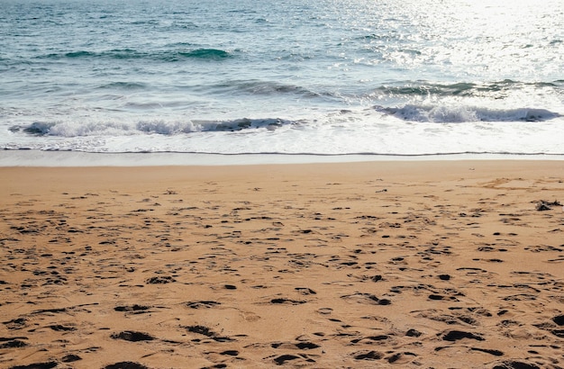 Foto onda dell'oceano sul fondo della spiaggia sabbiosa