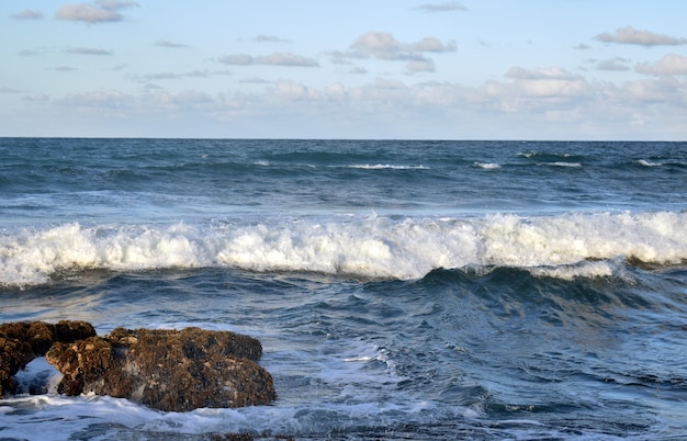 ocean waves are hitting the rocks