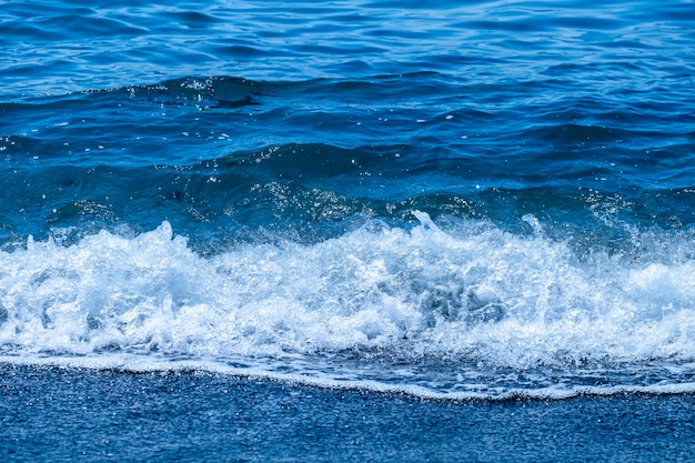 Ocean waves crashing on sandy beach Sea waves breaking on shore