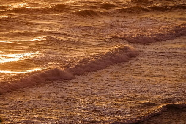 写真 温かい日没の海の波 光の美しい夏の背景