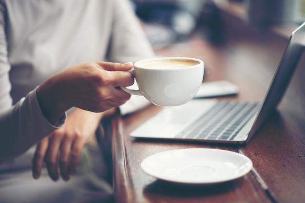 Ochtend koffie. De vrouw houdt een koffiekop, bedrijfsconcept