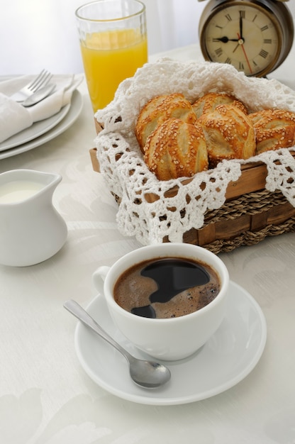 Ochtend kopje koffie met vers gebakken broodjes met sesamzaadjes, sap en melk