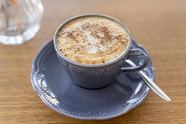 Ochtend kopje koffie op de achtergrond van het raam in de achtergrondverlichting van natuurlijk zonlicht cappuccin