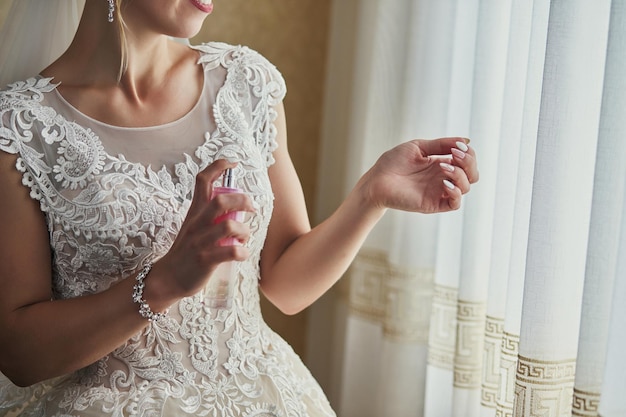 Ochtend van de bruid wanneer ze een mooie jurk draagt vrouw die zich klaarmaakt voor de huwelijksceremonie