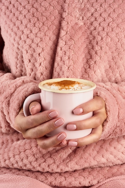 Ochtend warme chocolademelk op een koude herfstochtend, handen met een mok met een drankje, gezellige sfeer