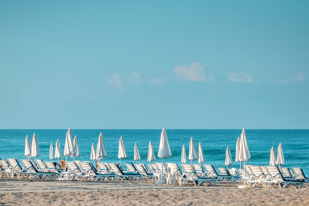 Ochtend zee, strand, lege ligbedden voor vakantiegangers. Vakantieconcept.