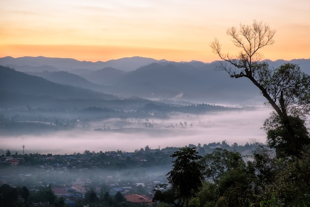 Ochtendbergdorp in de mist.