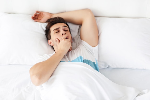 Ochtendconcept Geeuwde man in bed