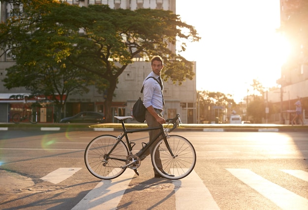 Ochtendfiets en zakenman in de stad voor woon-werkverkeer en ecologische voetafdruk Fietsvervoer en stedelijk met mannelijke werknemer die op zebrapad loopt voor reisdoorvoer en professional