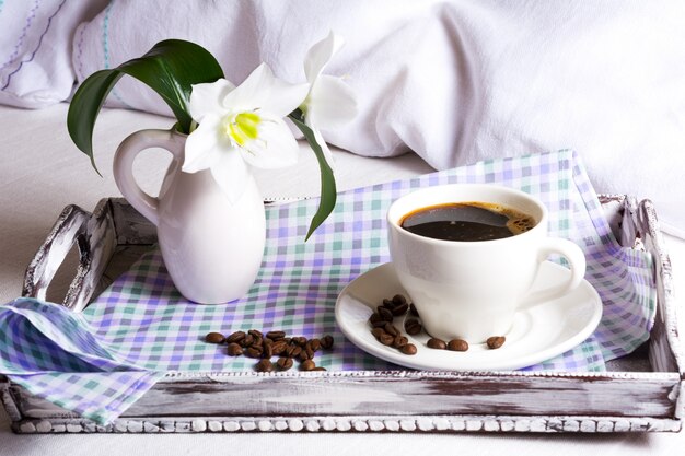 Ochtendkoffie in bed met witte leliebloemen