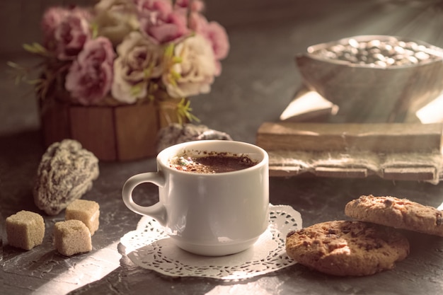 Ochtendkoffie met koekjes en stukken rietsuiker in de zon.