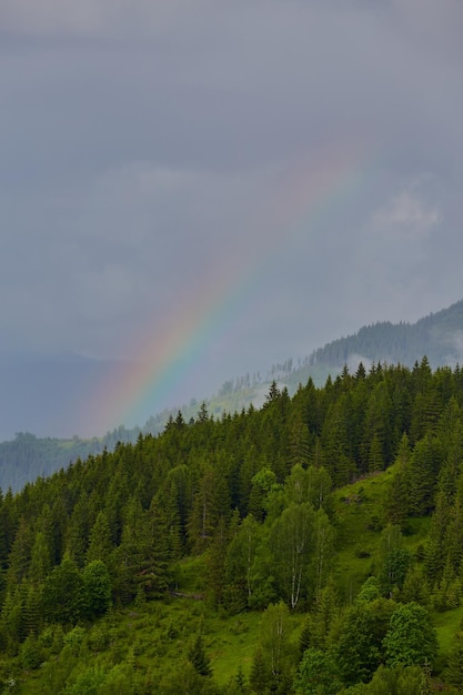 Ochtendmist met roodgloeiende zonsopgang en regenboog in de bergen