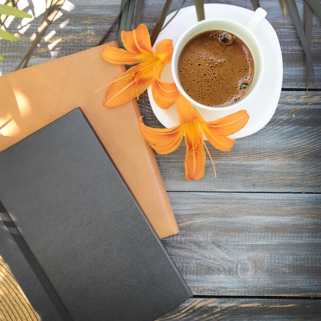 Ochtendmodel met koffie en notitieboekjes op een platte houten tafel