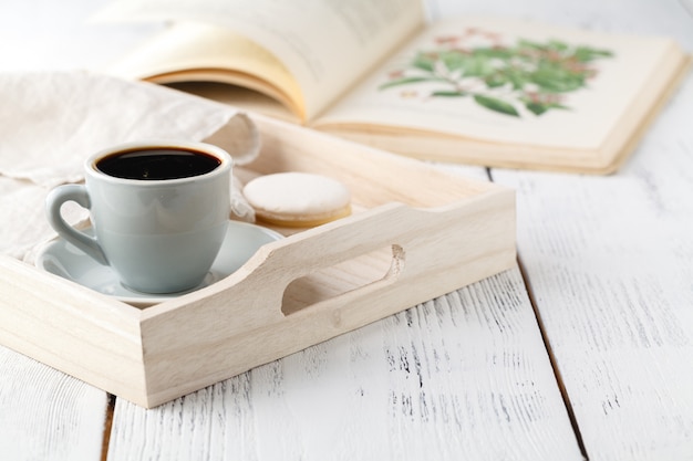 Ochtendontbijt, mok met koffie, boek op een houten dienblad