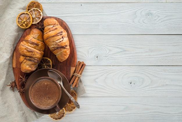 Ochtendontbijt, samenstelling van koffie en croissants op een houten achtergrond