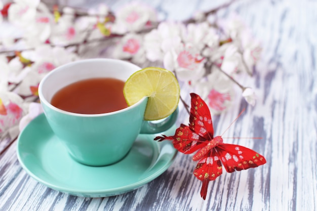 Ochtendontbijt van thee in een kop roze bloemen en met een plak
