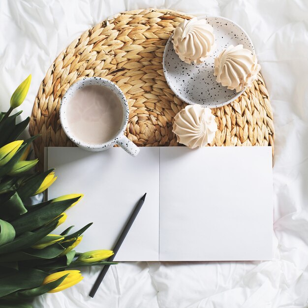 Ochtendstilleven met kopje koffie, tulpen en schetsboek. bovenaanzicht, vierkant