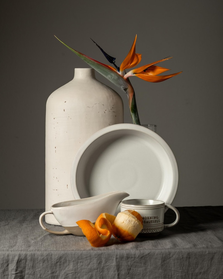 Foto ochtendstillevenkop met thee, croissant, oranje exotische bloem
