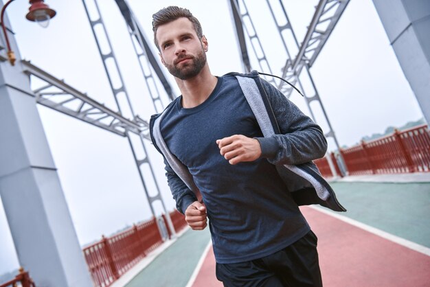 Ochtendtraining close-up van jonge man in sportkleding die traint tijdens het joggen op de?