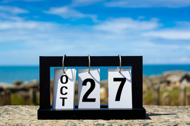Photo oct 27 calendar date text on wooden frame with blurred background of ocean calendar date concept