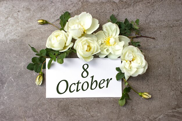 October 8th. day 8 of month, calendar date. white roses border\
on pastel grey background with calendar date. autumn month, day of\
the year concept.