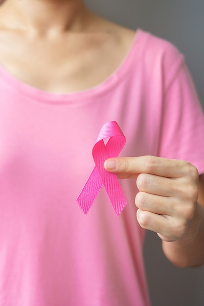 October Breast Cancer Awareness month, elderly Woman in pink T- shirt with hand holding Pink Ribbon for supporting people living and illness. International Women, Mother and World cancer day concept