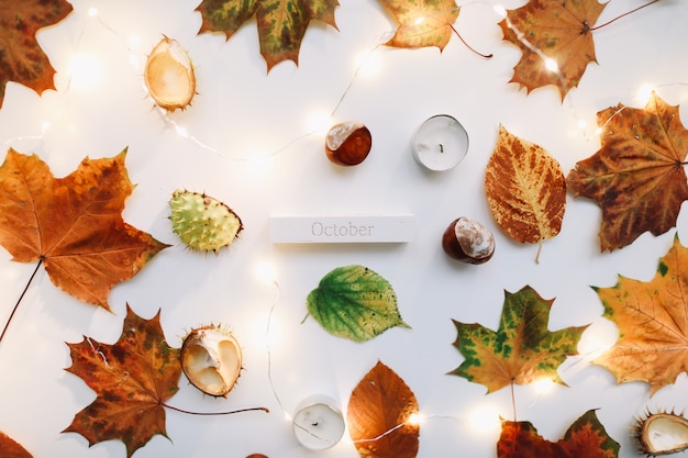 October flat lay and autumn composition with leaves candles and chestnuts top view