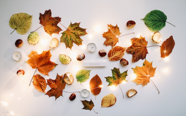 October flat lay and autumn composition with leaves candles and chestnuts top view