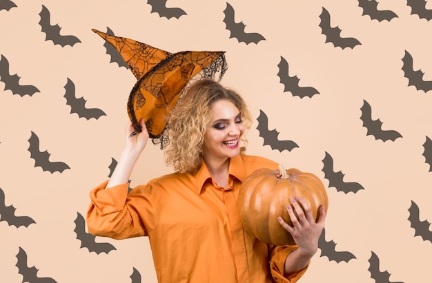 Foto ottobre donna sorridente con zucca di halloween dolcetto o scherzetto felice halloween strega di halloween con