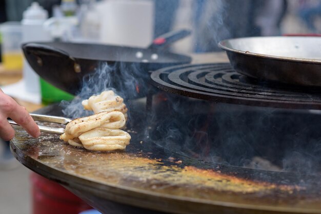 Octopus meat is prepared at the street food festival with smoke and fire