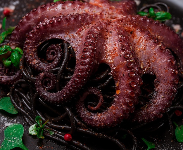 Octopus met zwarte spaghetti pasta specerijen en kruiden bovenaanzicht geen mensen