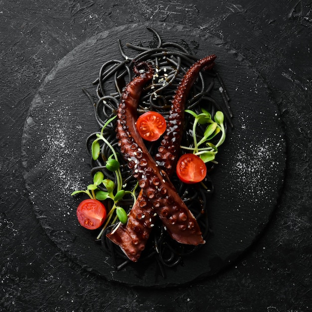 Tentacoli di polpo cotti in salsa all'aglio e pasta nera al nero di seppia cibo da ristorante di lusso frutti di mare stile rustico piatto lay