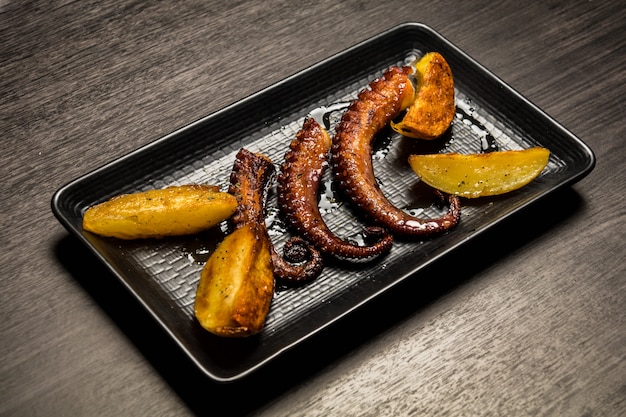 Photo octopus tentacles grilled with potatoes