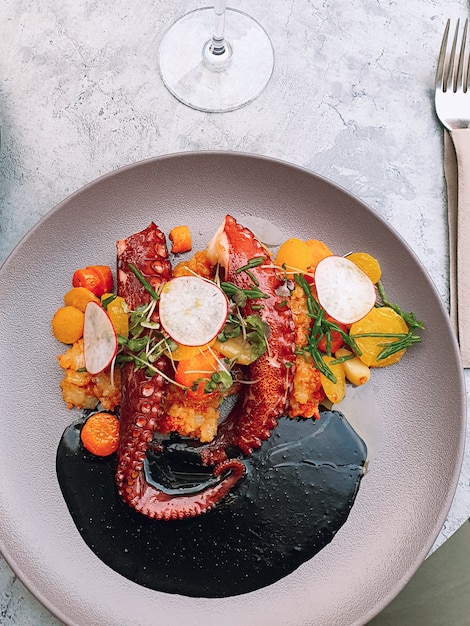 Photo octopus with vegetables with cuttlefish ink