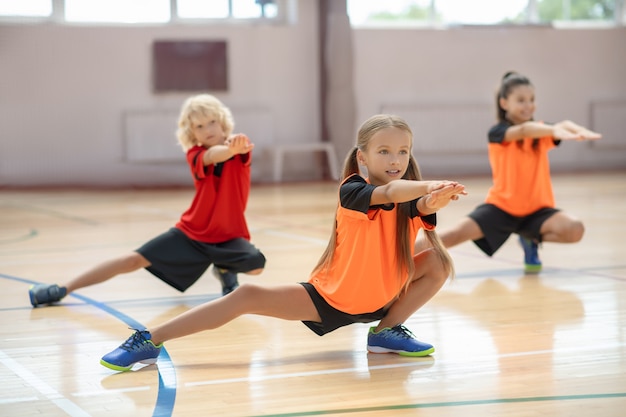 Foto oefenen. drie kinderen trainen in de sportschool en zien er geconcentreerd uit