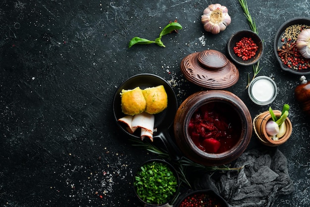 Oekraïens eten Borsch met reuzel knoflook en donuts op een zwarte stenen achtergrond Bovenaanzicht Rustieke stijl