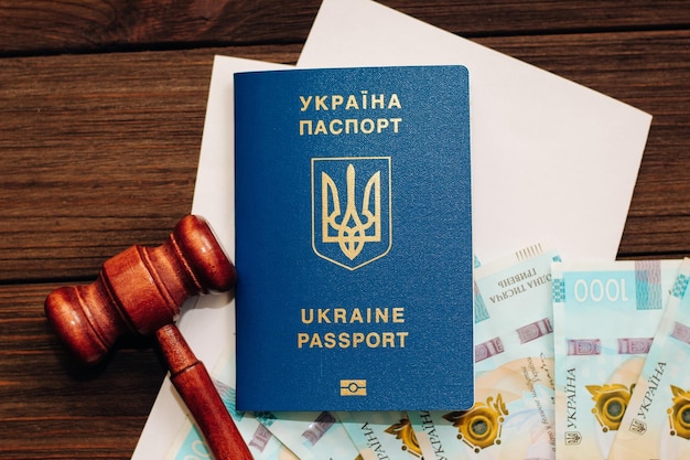 Oekraïens hryvnia-geld op tafel met documenten met plaats voor tekst en een paspoort naar Oekraïne