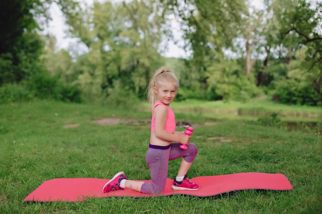 Oekraïens mooi 7-jarig meisje met wit haar als een engel is bezig met fitness