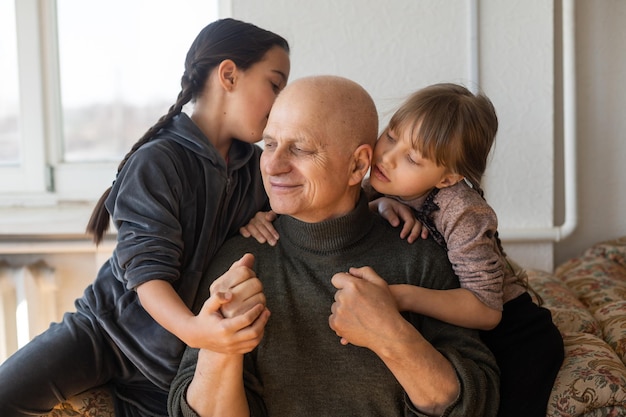 Oekraïense grootvader en twee kleindochters knuffelen