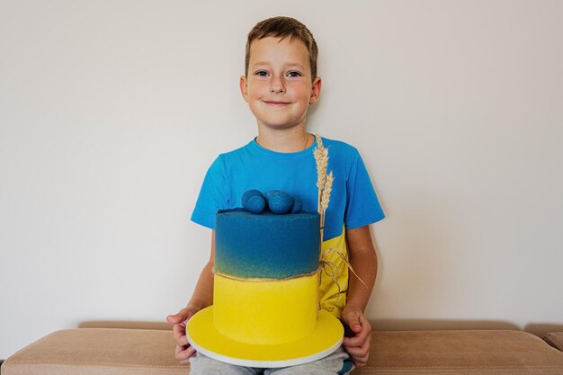 Oekraïense jongen die verjaardag viert met grote taart met vlag van Oekraïne