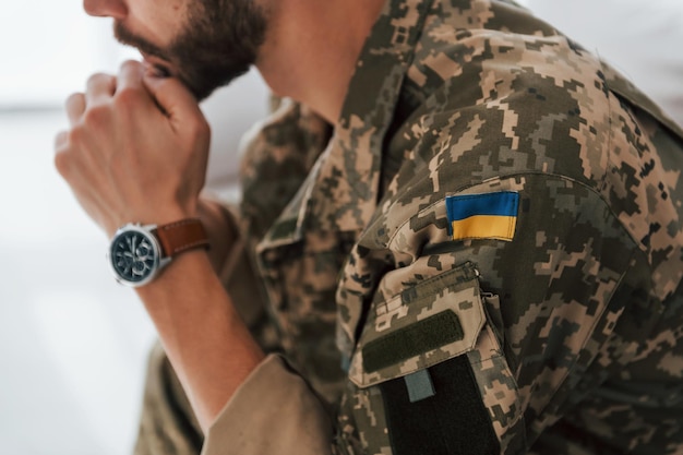 Oekraïense vlag Soldaat in uniform is binnen in de huiskamer